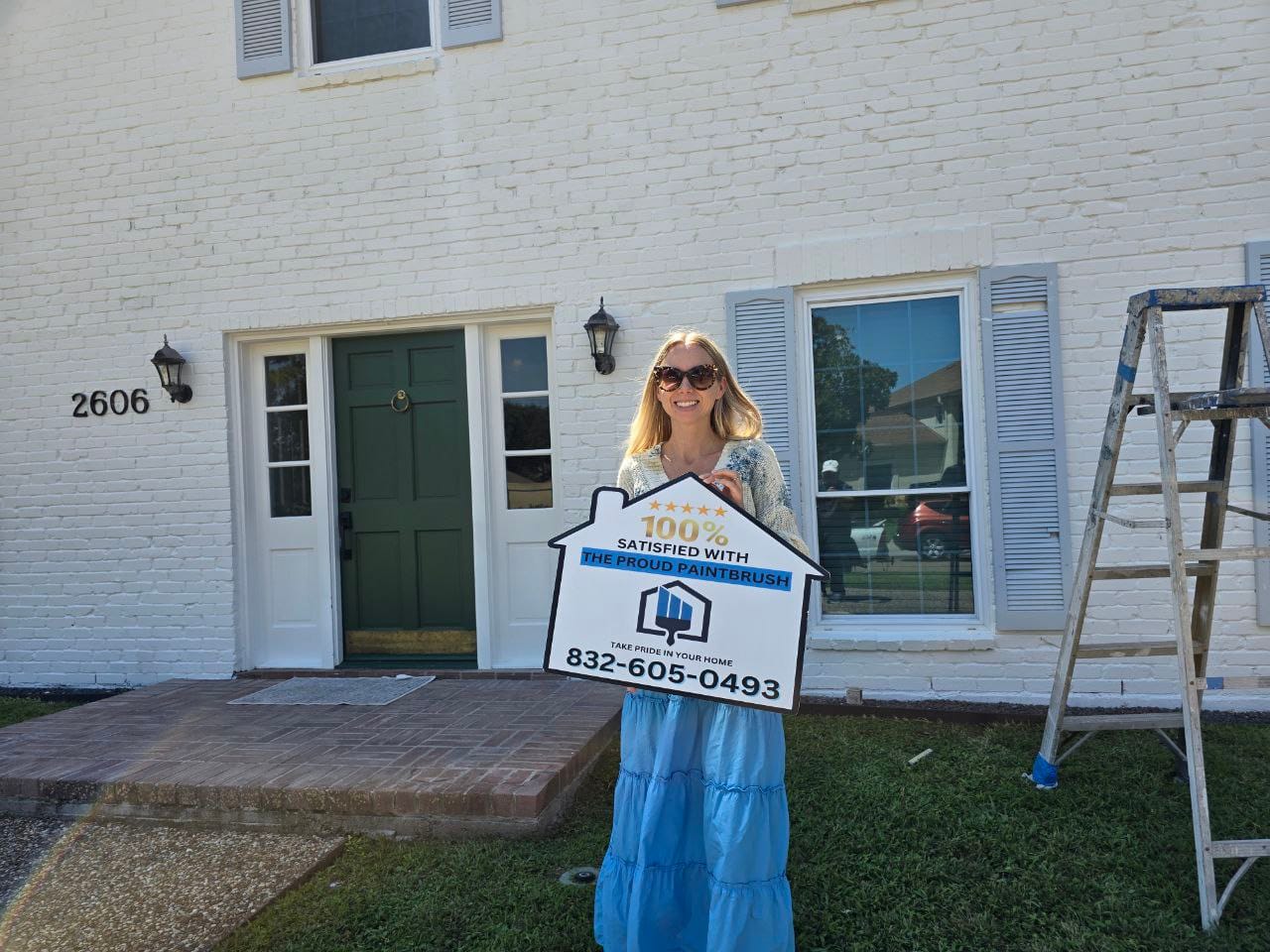 Happy customer in front of a freshly painted white brick home in Katy, TX