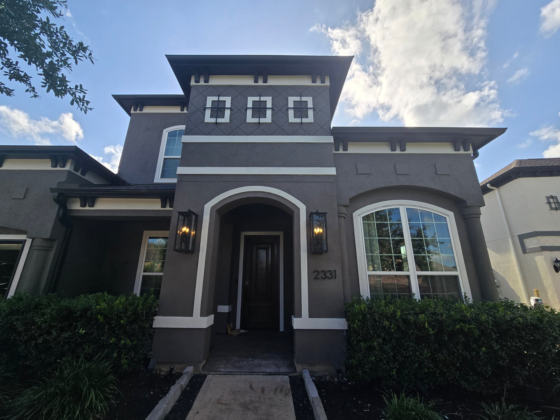 Freshly painted two-story home exterior by The Proud Paintbrush in Fort Bend County, TX