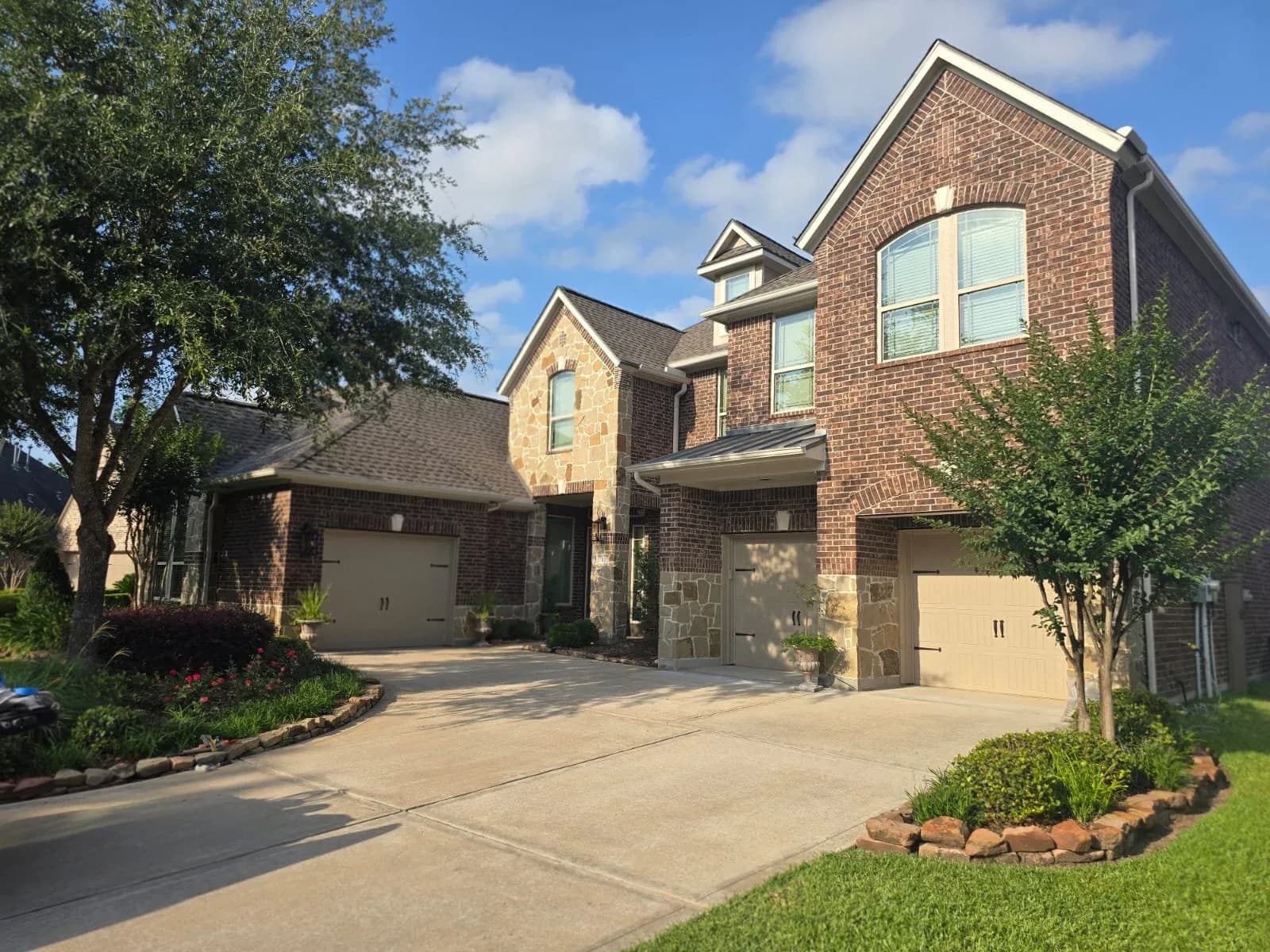Brick and stone two-story home exterior in Rosenberg, TX by The Proud Paintbrush