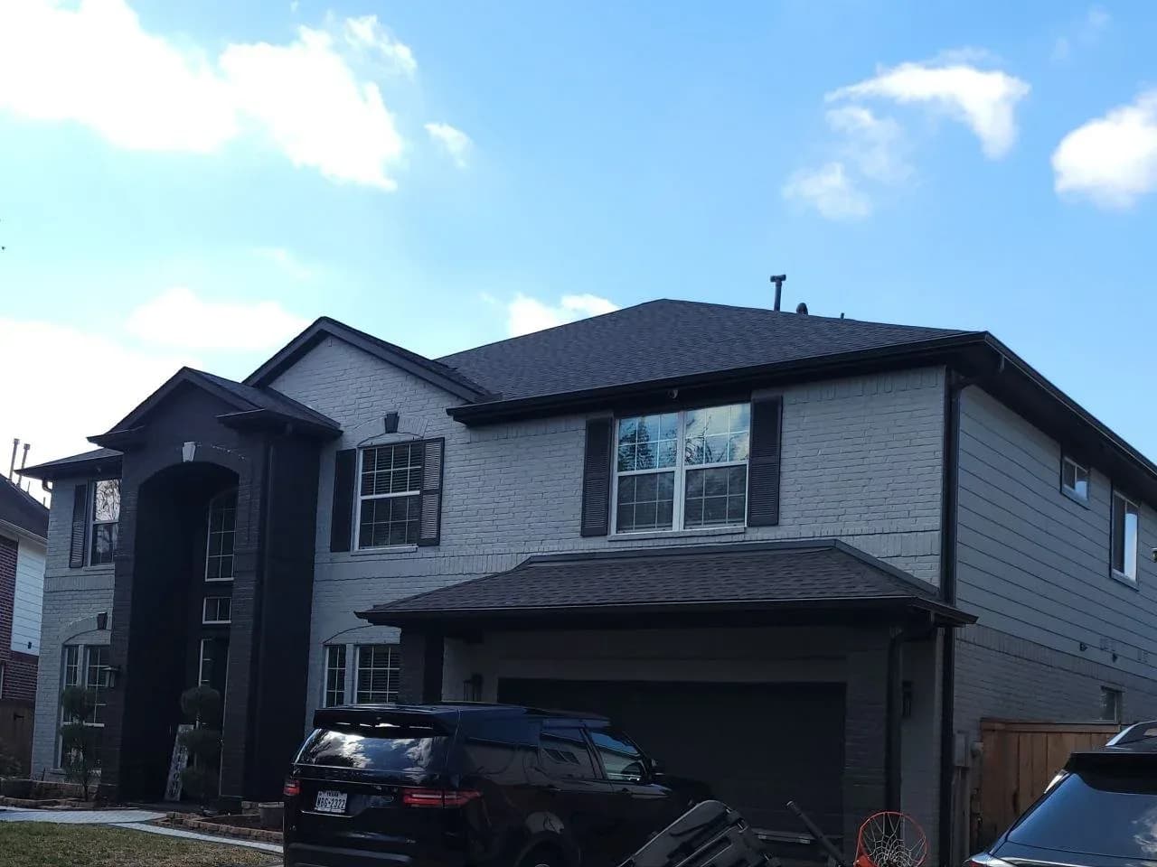 Gray painted brick two-story home exterior in West Houston, TX by The Proud Paintbrush