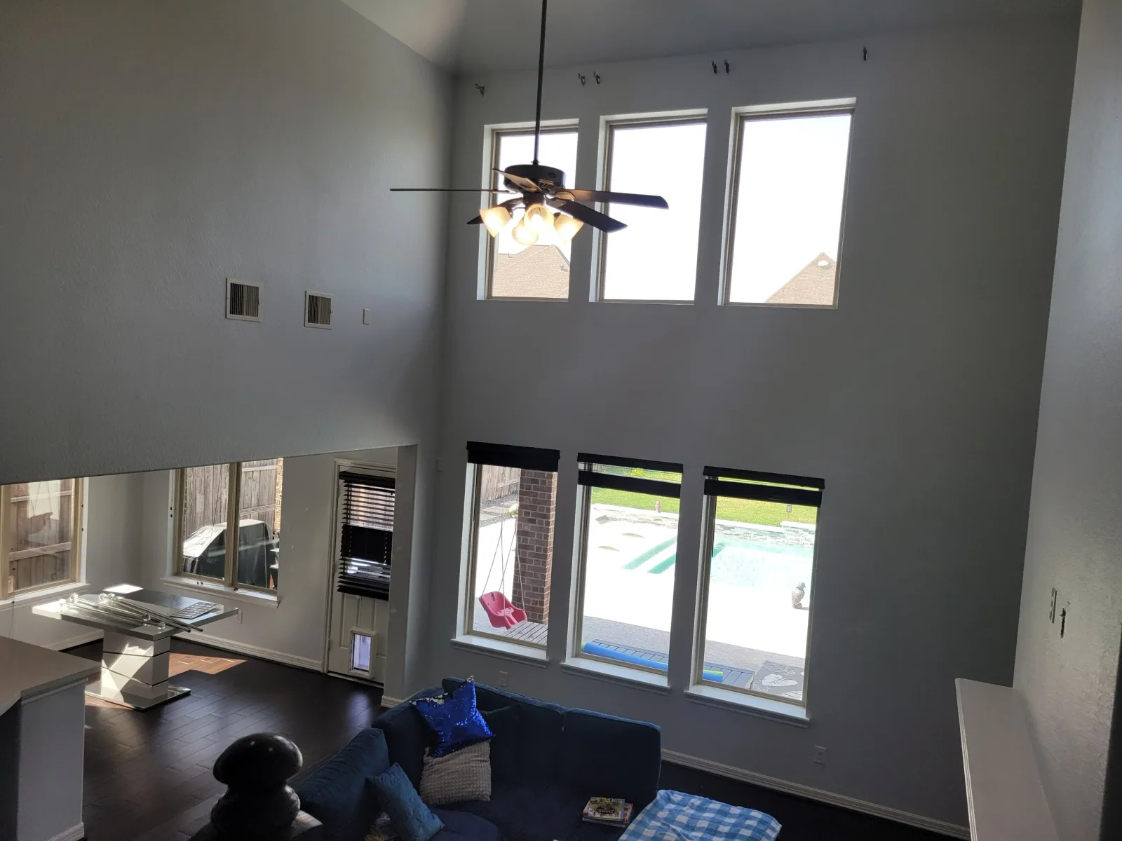 Two-story living room with gray walls repainted in Richmond, TX by The Proud Paintbrush
