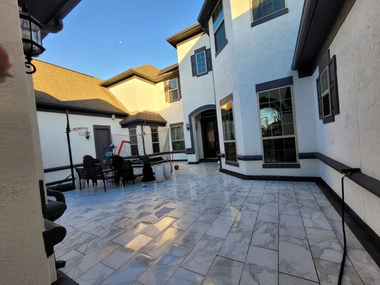 Stucco home with courtyard and tile patio painted in Katy, TX by The Proud Paintbrush