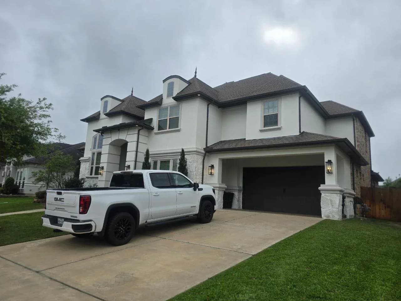 Limewashed stucco and stone home exterior in Fulshear, TX by The Proud Paintbrush