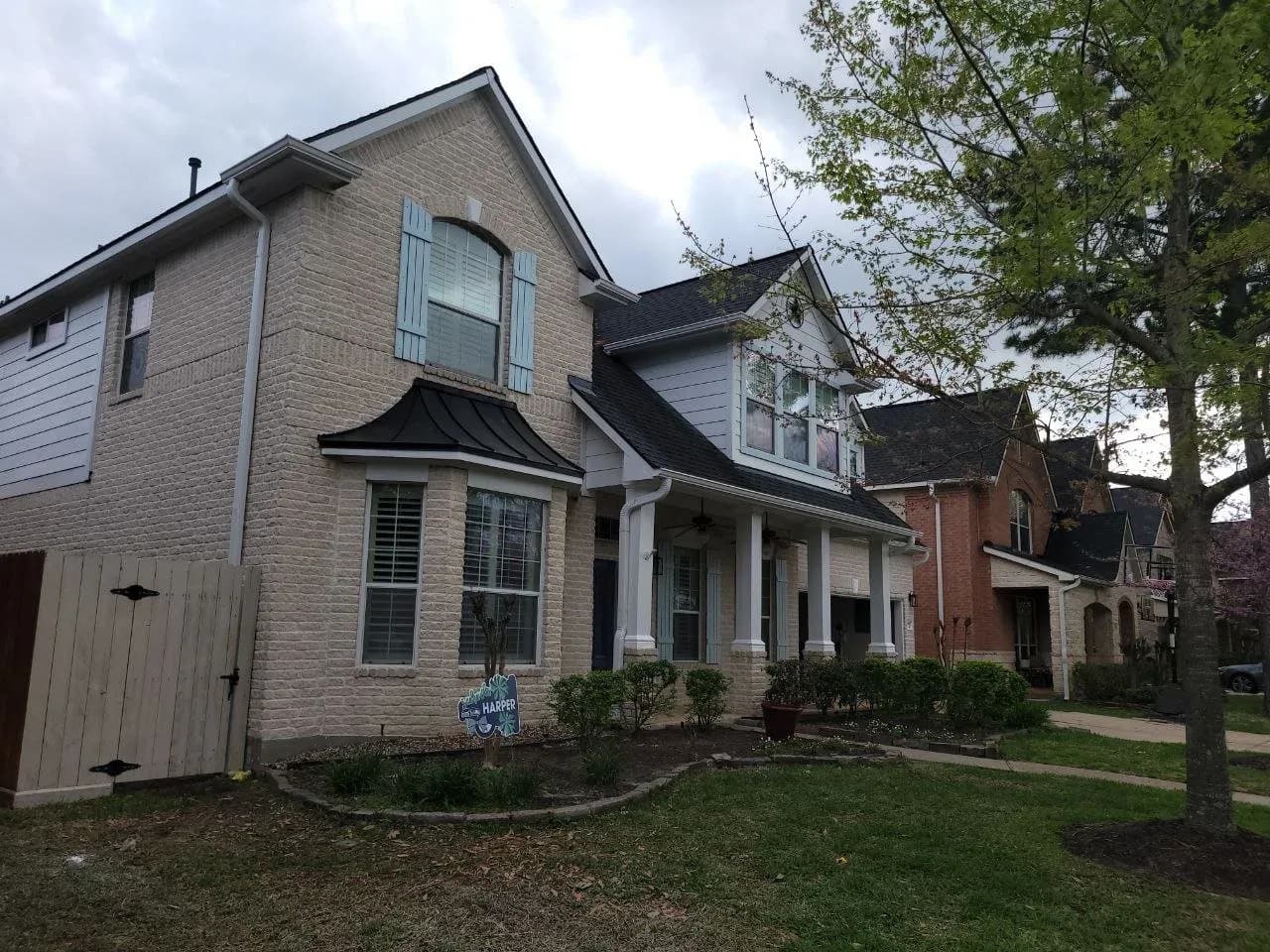 Two-story brick home exterior freshly painted in Katy, TX by The Proud Paintbrush