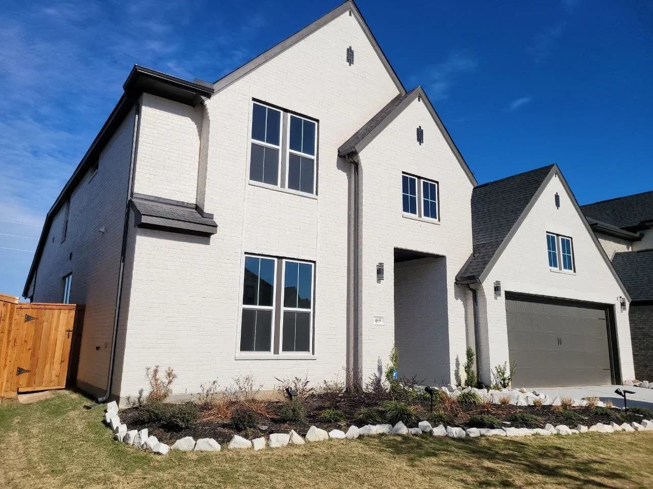 White painted brick two-story home exterior in Katy, TX by The Proud Paintbrush