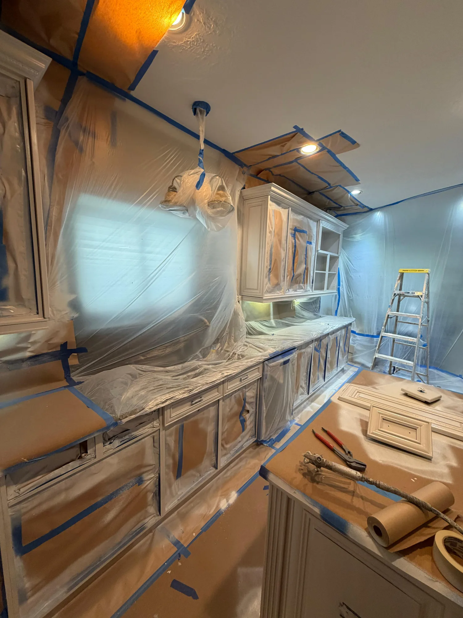 Cabinet painting prep and masking process on a kitchen repaint in Katy, TX