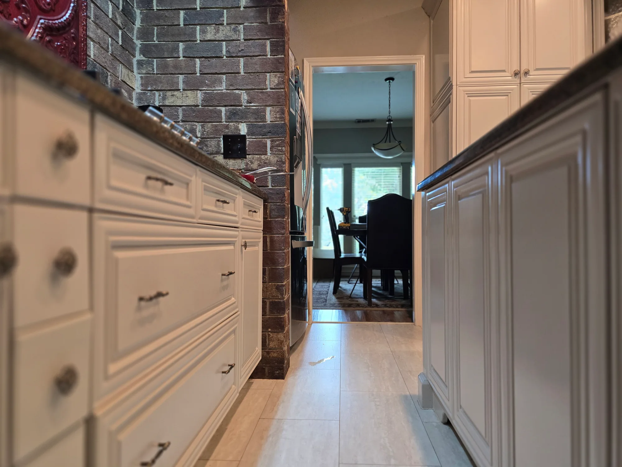 Refinished kitchen cabinets in Revere Pewter beside a brick oven surround accent, Memorial Parkway, Katy TX