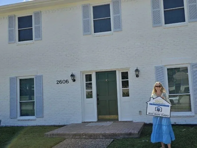 Freshly painted brick house with blue shutters and satisfied homeowner in Rosenberg, Texas