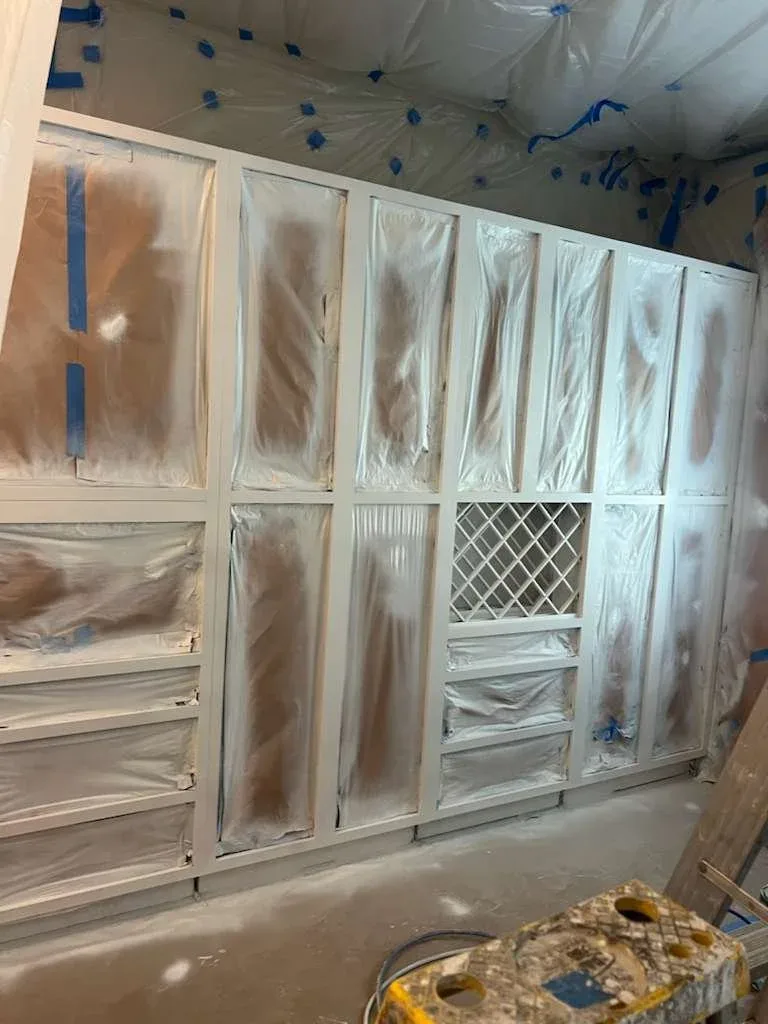 Freshly painted kitchen cabinets with masking still in place and top coat applied in Katy, Texas