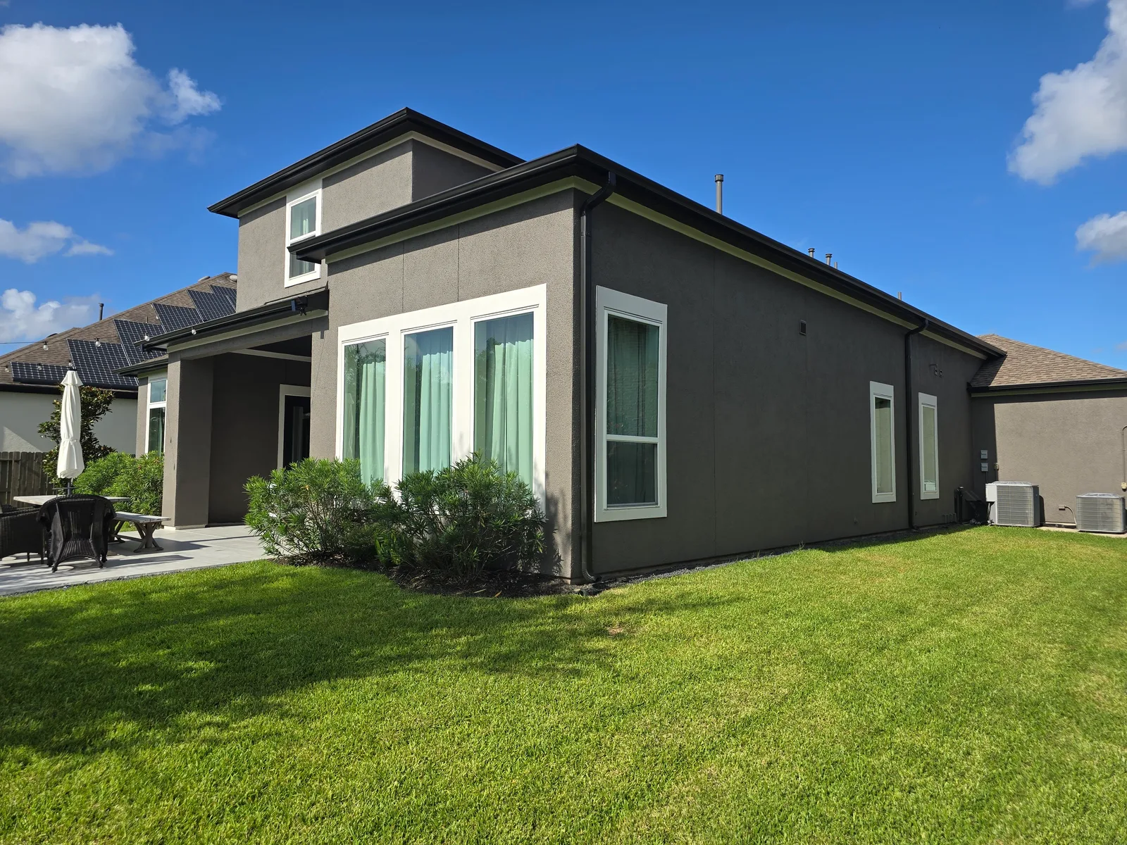 Backyard exterior stucco repaint in Missouri City, TX, painted charcoal by The Proud Paintbrush