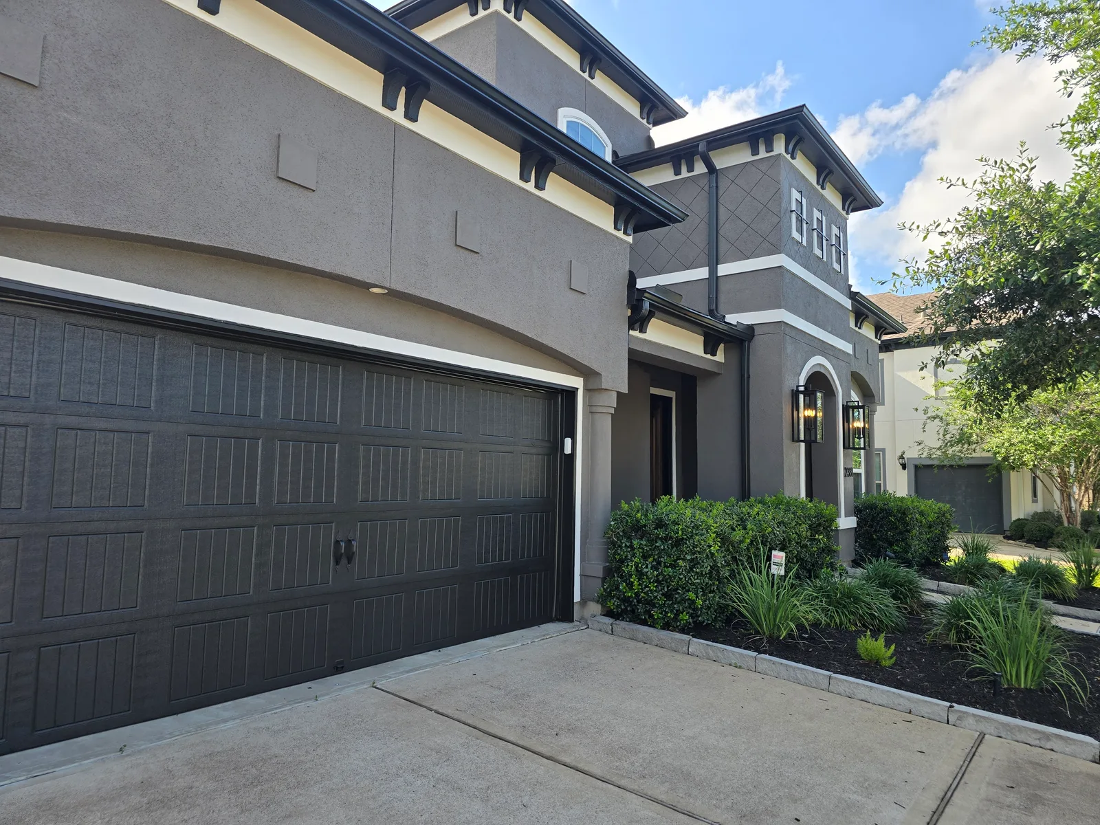 Double garage exterior stucco repaint in Missouri City, TX, painted charcoal by The Proud Paintbrush