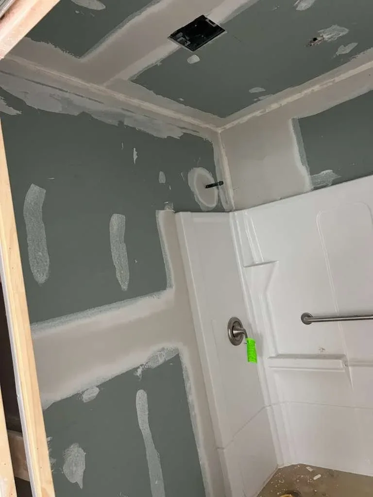 New drywall installed and being taped and floated during interior wall repair in Southwest Houston, Texas.