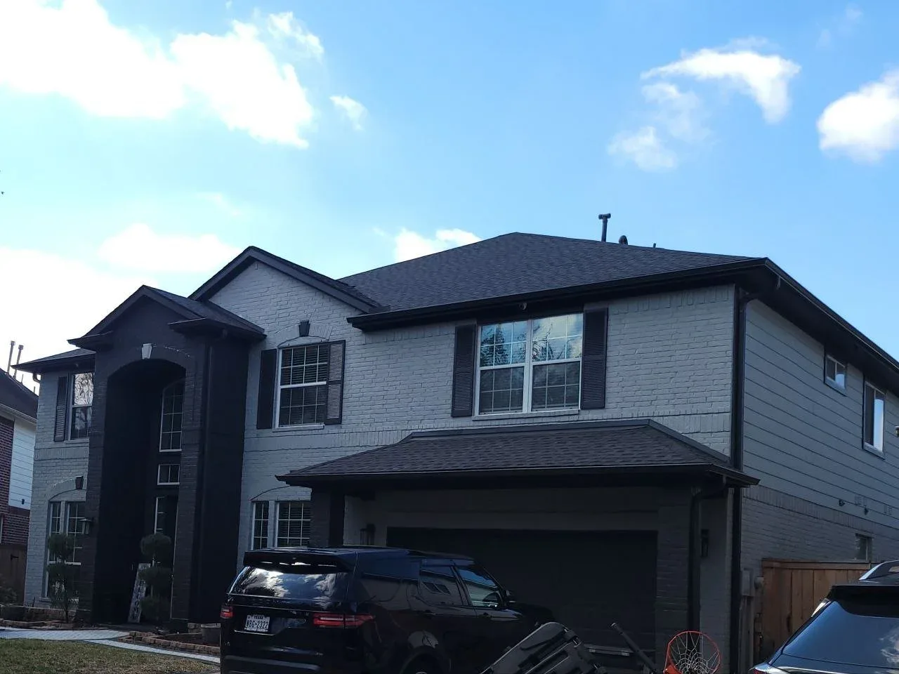 Gray painted brick two-story home exterior in West Houston, TX by The Proud Paintbrush