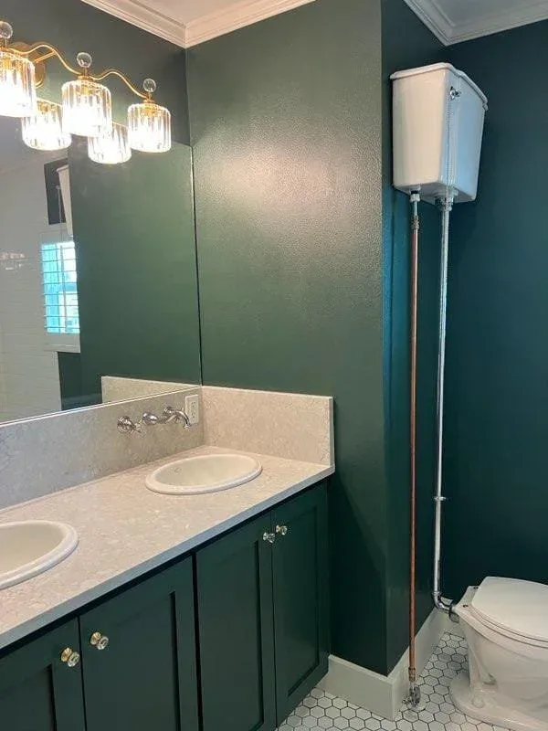 Freshly painted green bathroom vanity and matching green walls in a Southwest Houston home