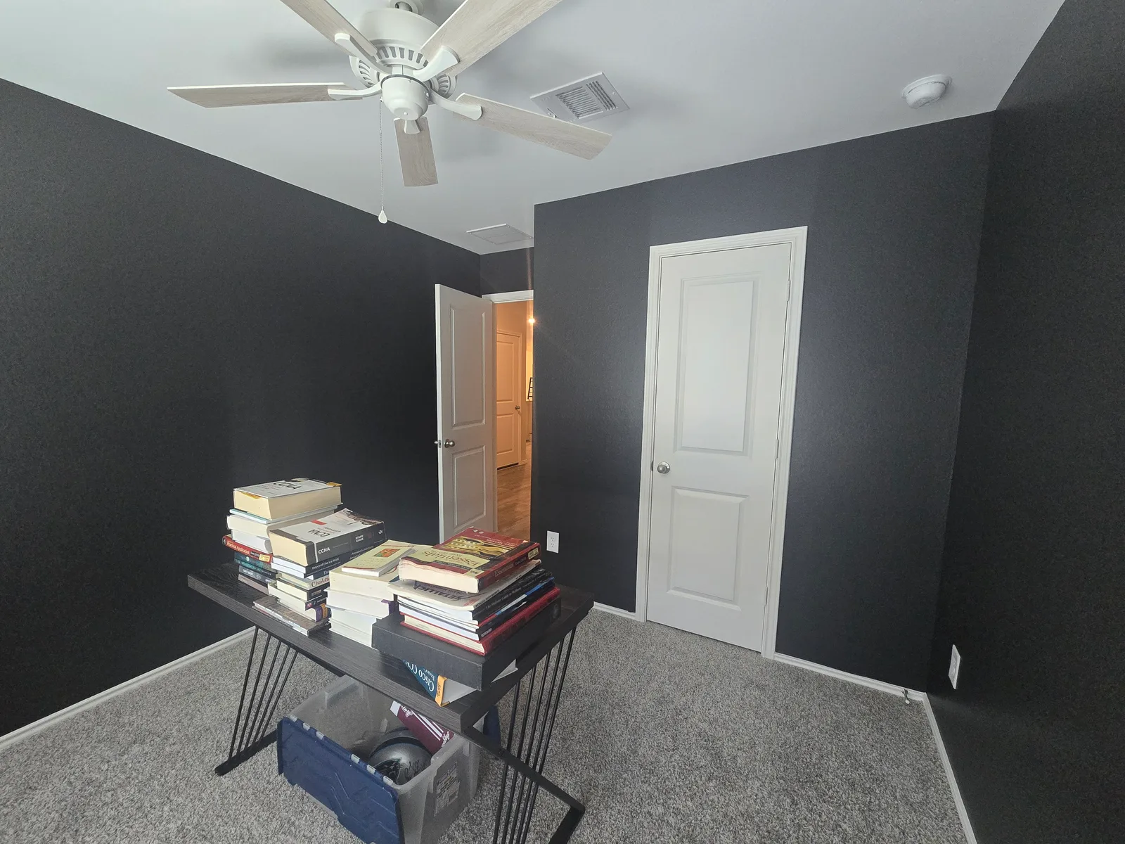 Home office with a dark accent wall and white trim in a Fulshear, TX home before its whole-home interior repaint
