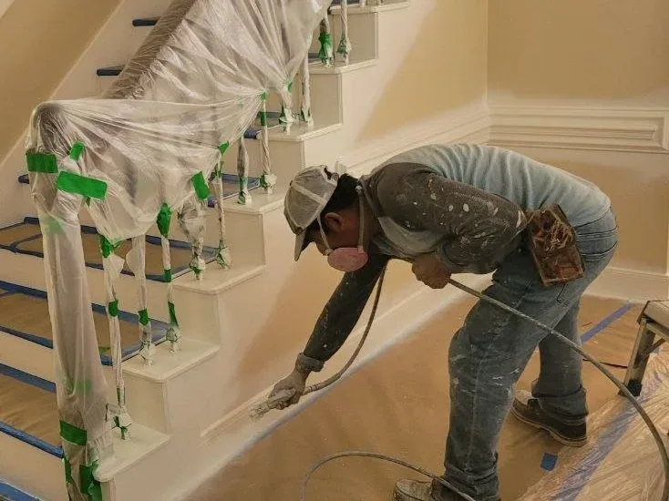 Interior home masked and prepared for spraying baseboards and stairs with an airless sprayer in Katy, Texas.