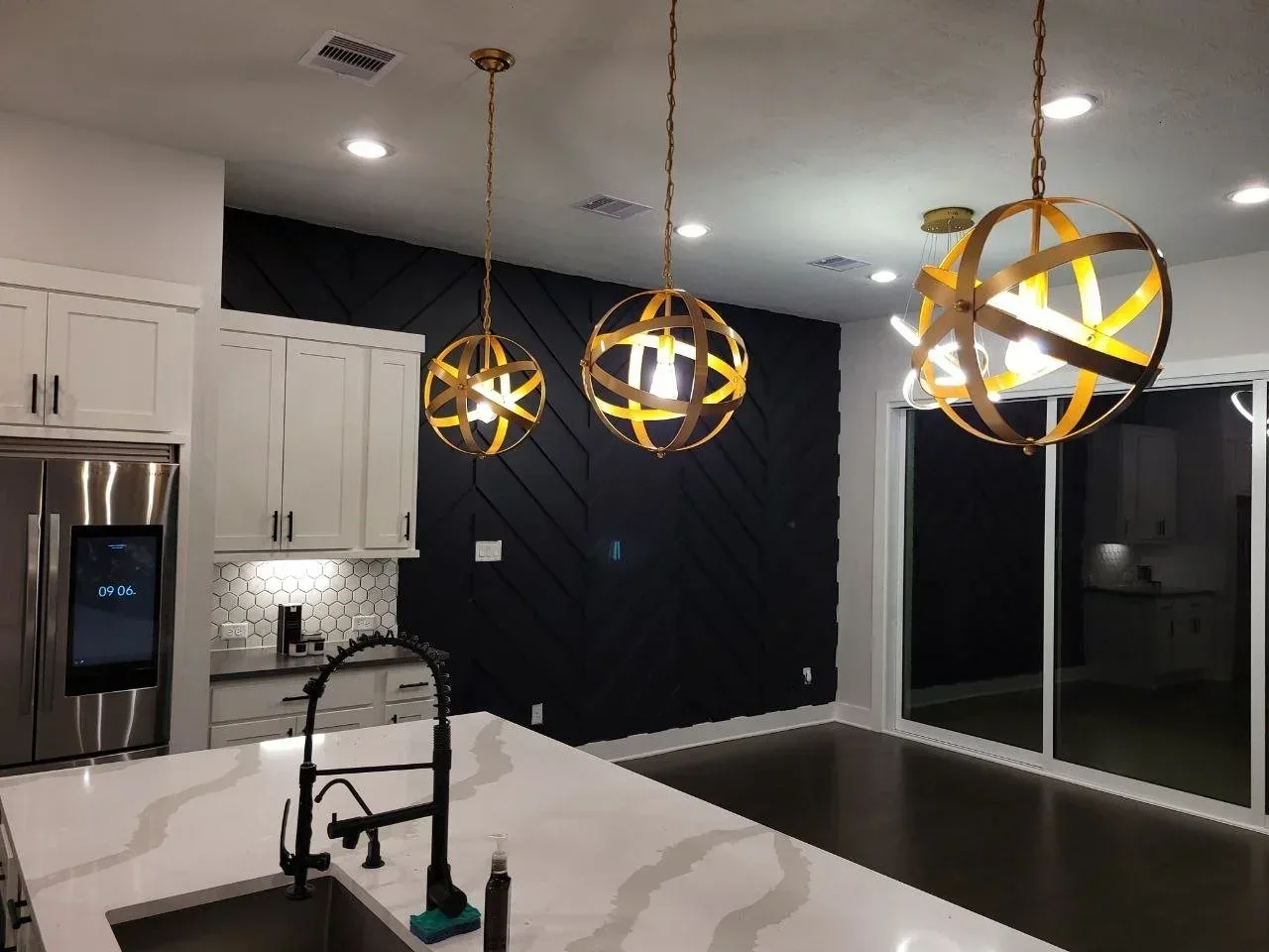 Freshly painted kitchen and breakfast area with black feature wall, white walls, and white cabinets in Richmond, Texas