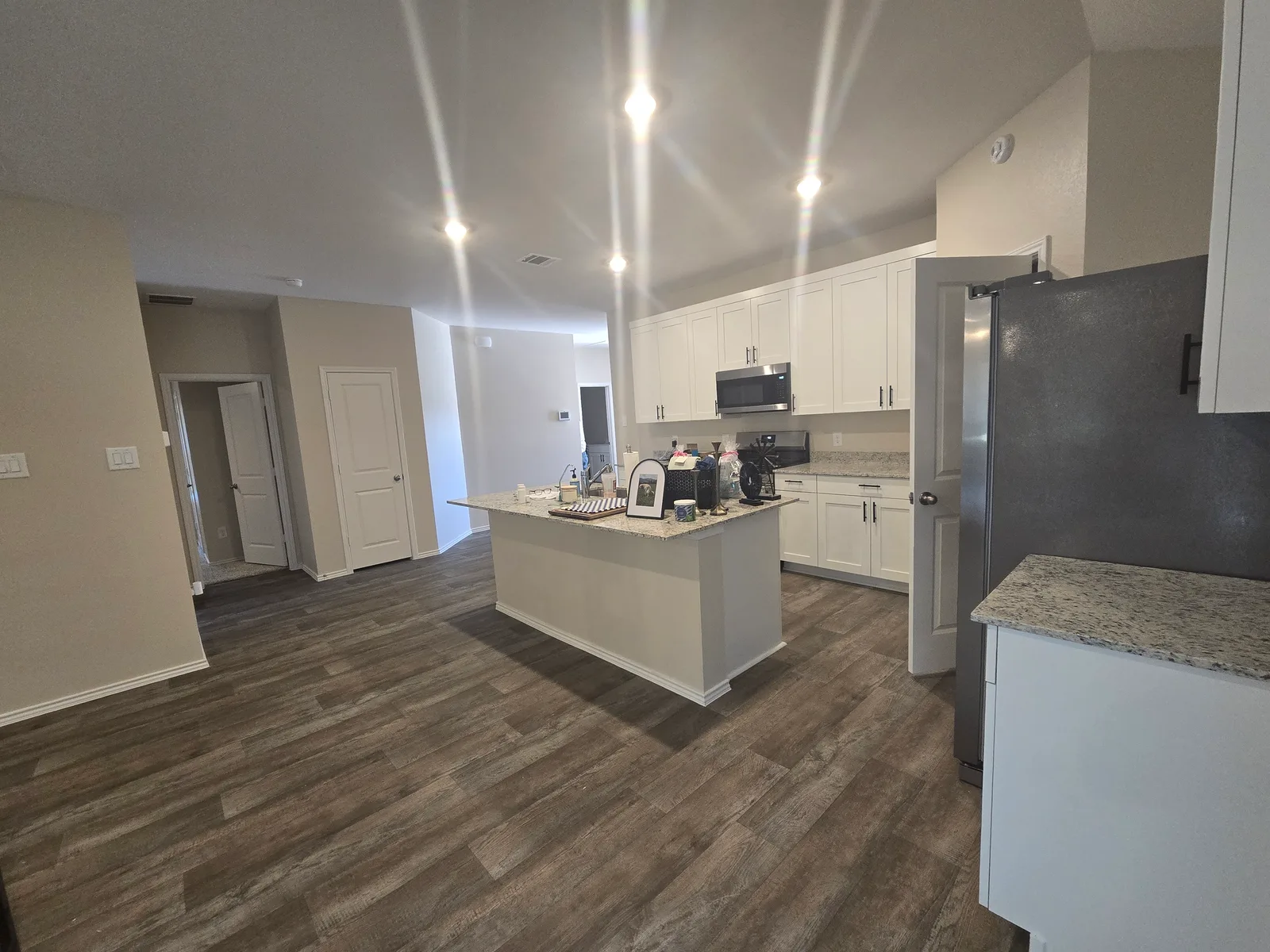 Open-concept kitchen with builder-grade white walls in a Fulshear, TX home before its whole-home interior painting by The Proud Paintbrush
