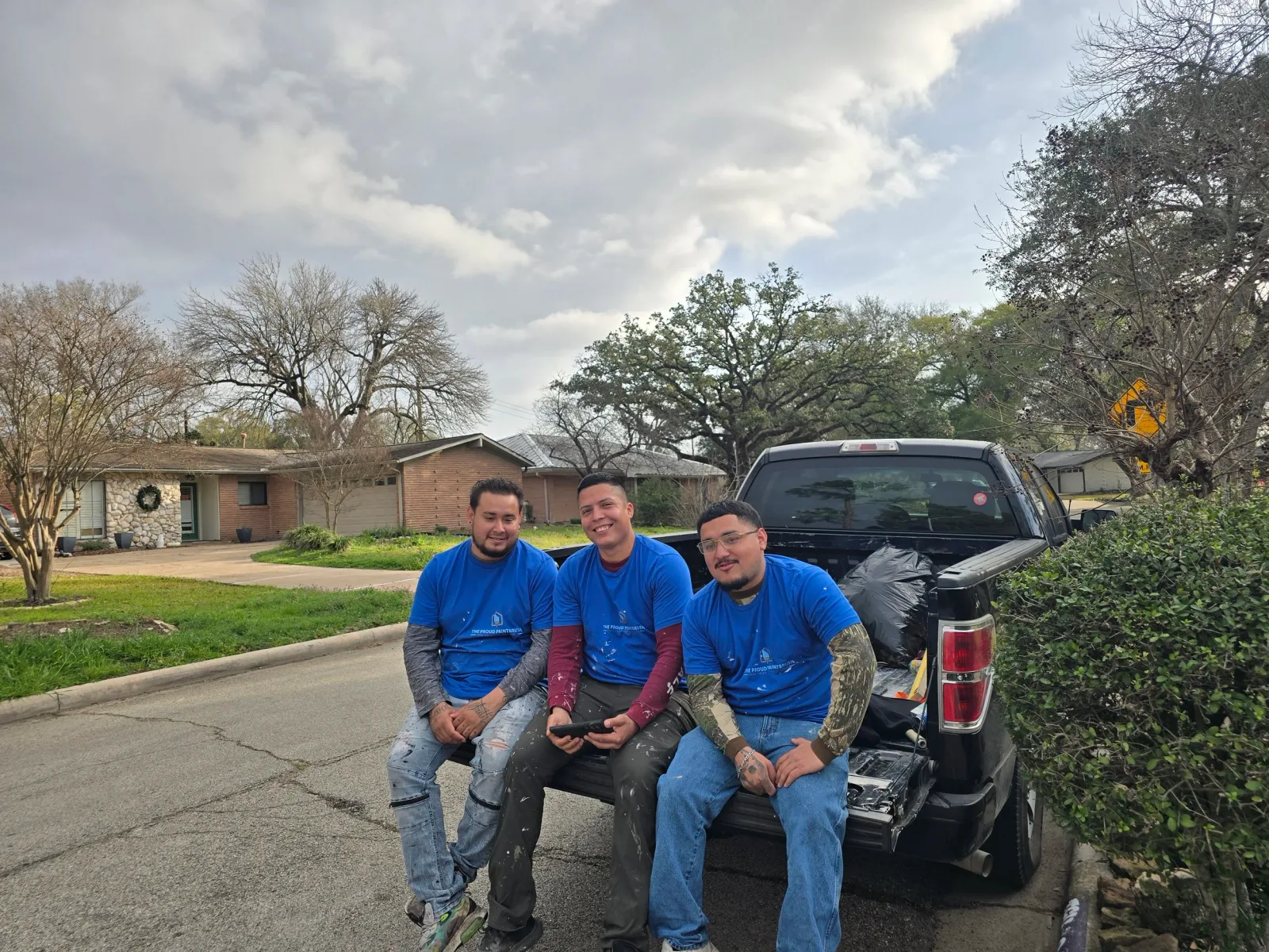 Three professional painters outside a home during Paint It Forward 2026 in West Houston, Texas.