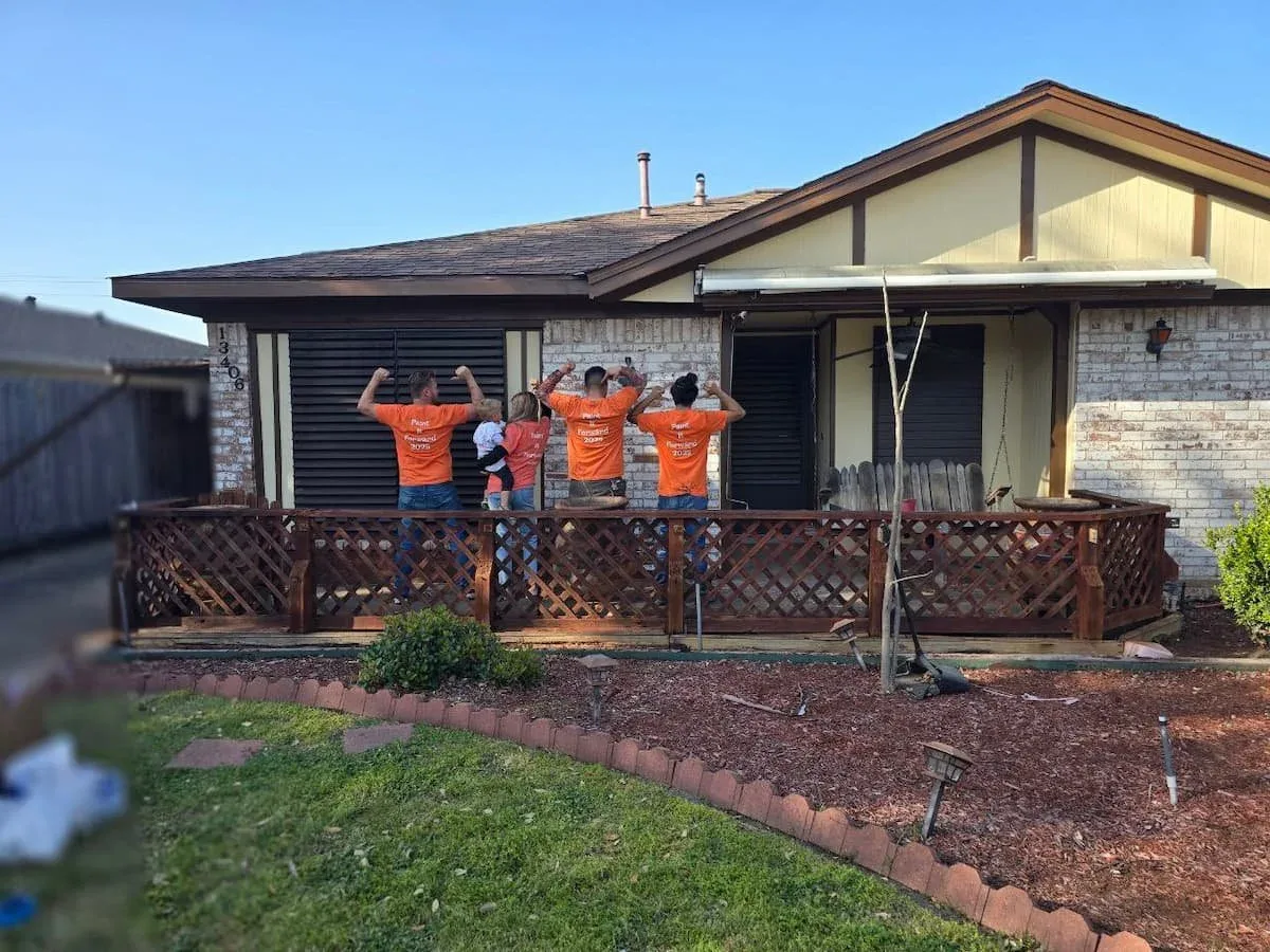 Group of volunteers and family standing outside the completed Paint It Forward home in Sugar Land TX