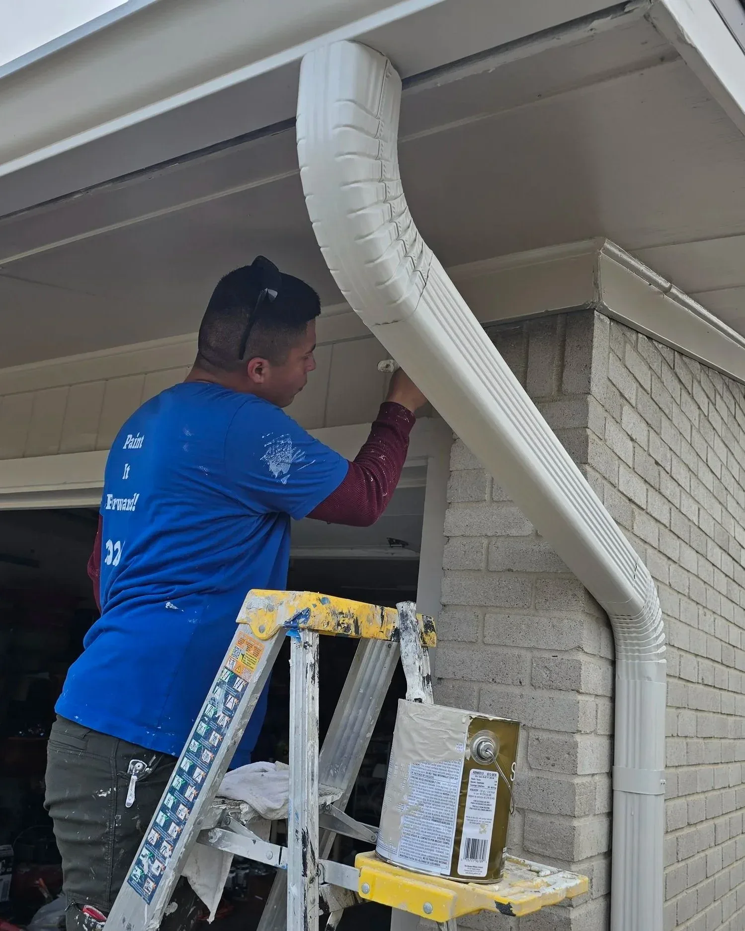 Painter preparing and painting exterior trim during residential project in Richmond, TX by The Proud Paintbrush.