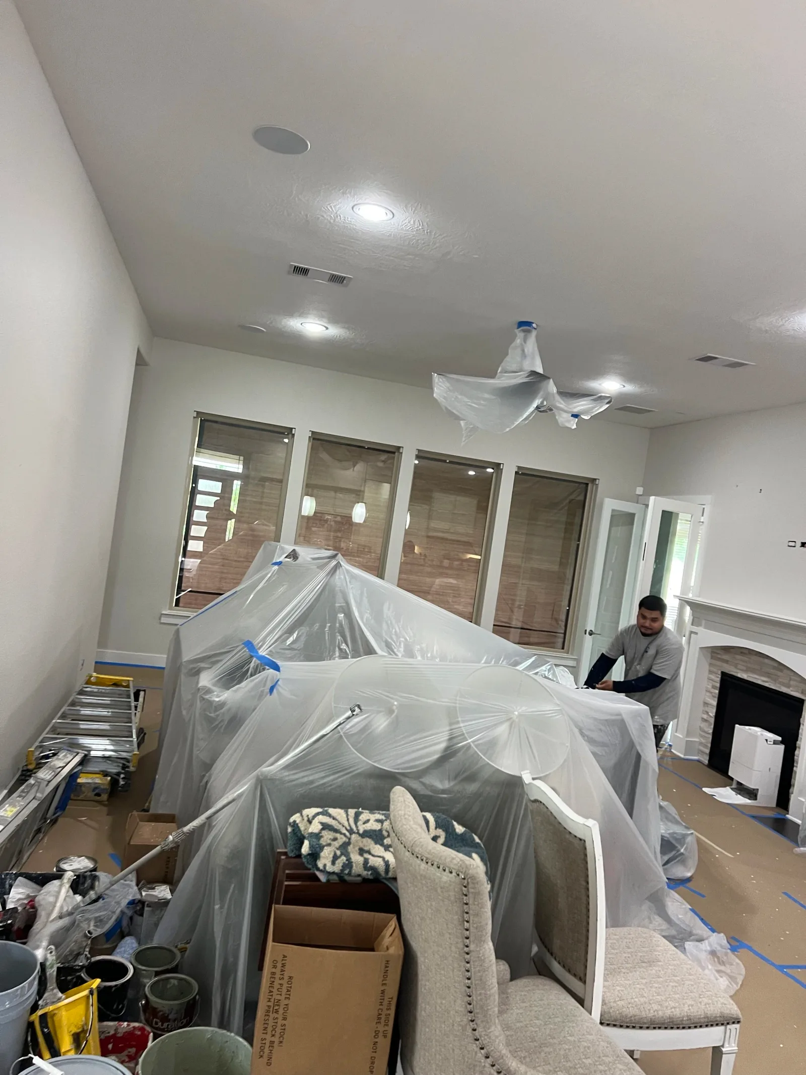 Interior painting preparation with furniture masking and surface protection in Sugar Land, TX by The Proud Paintbrush.