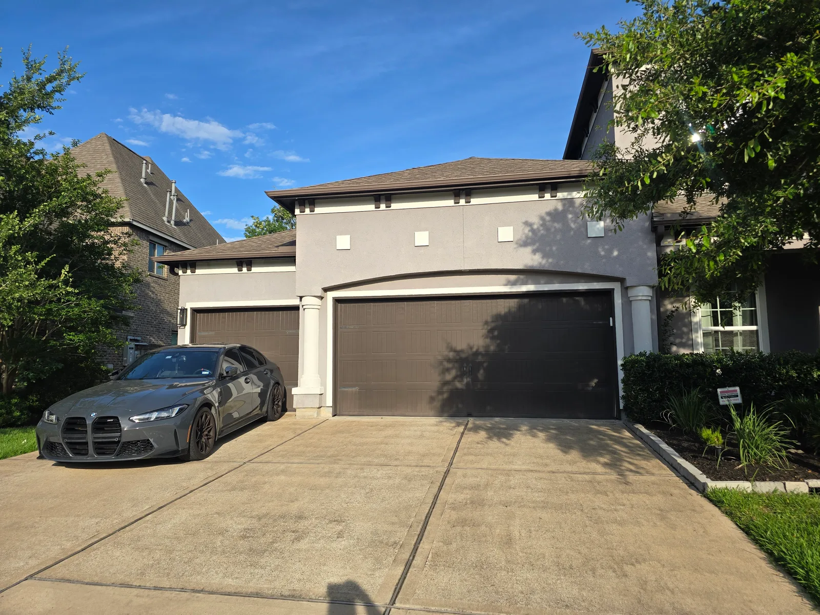 Faded tan stucco double garage exterior before repaint, Missouri City, TX