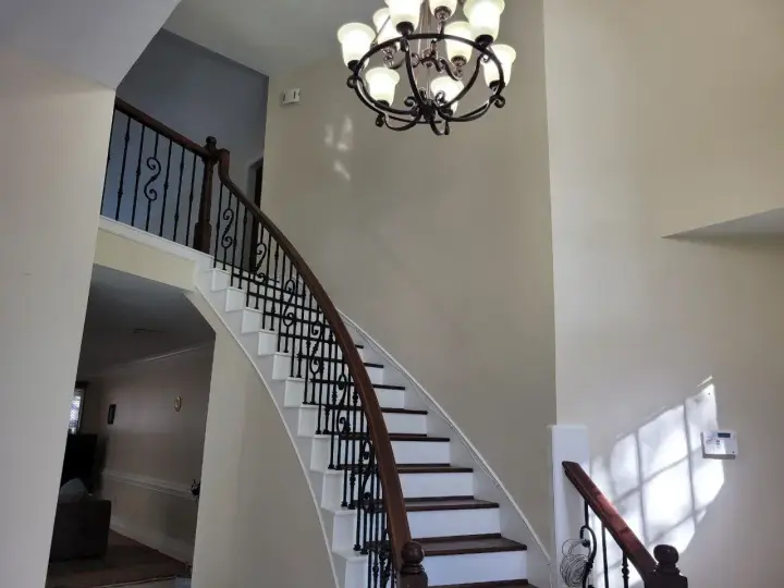 Interior staircase and entryway repaint with detailed trim work and consistent wall finishes for a polished, seamless transition between levels.