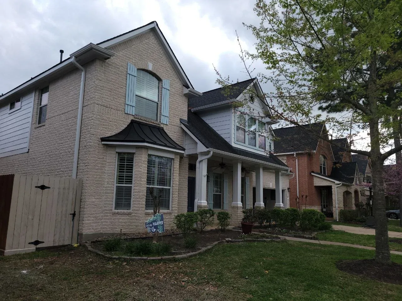 Two-story brick home exterior freshly painted in Katy, TX by The Proud Paintbrush