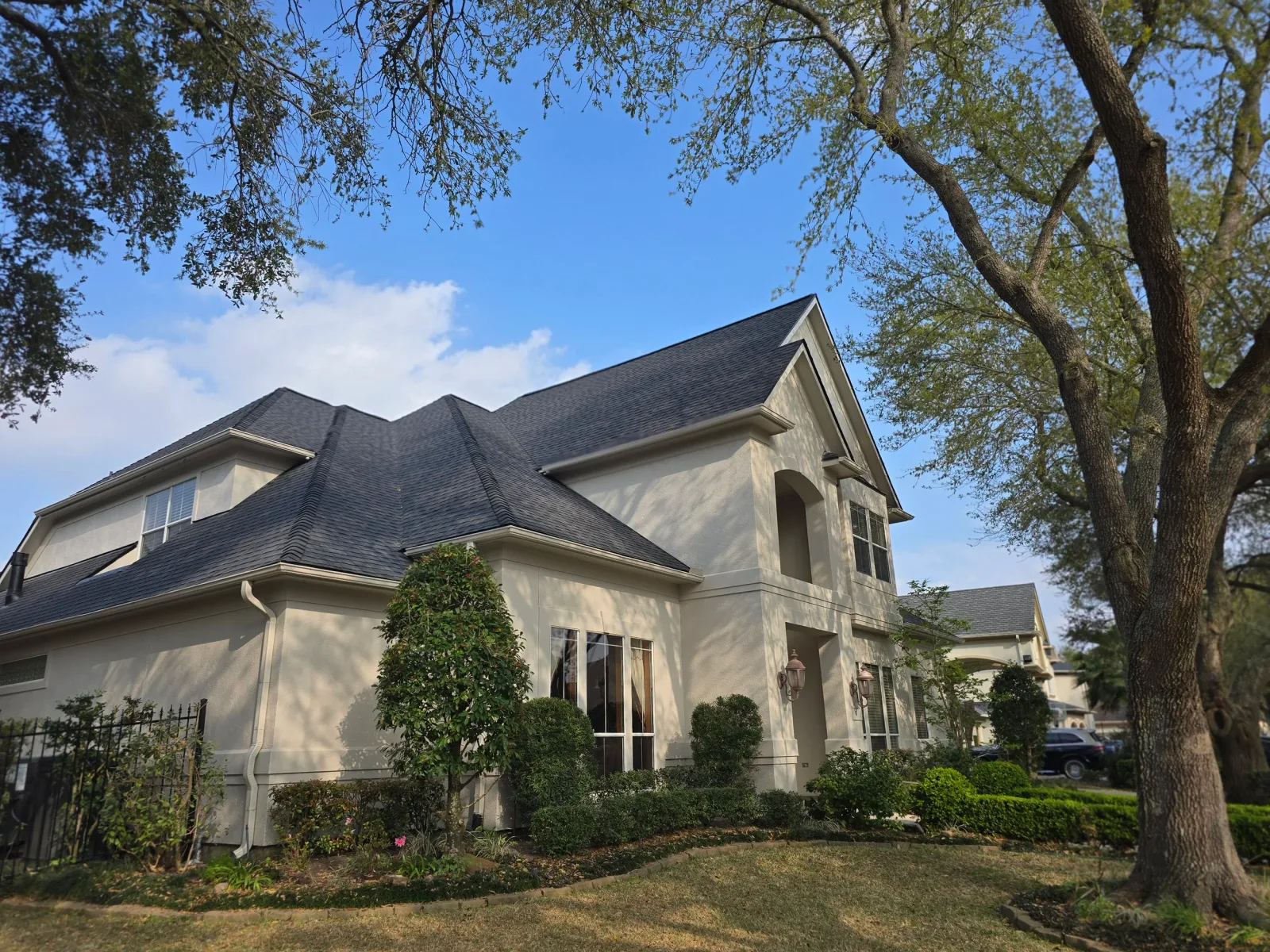Two-story home exterior painting project in Katy, Texas with updated stucco and trim