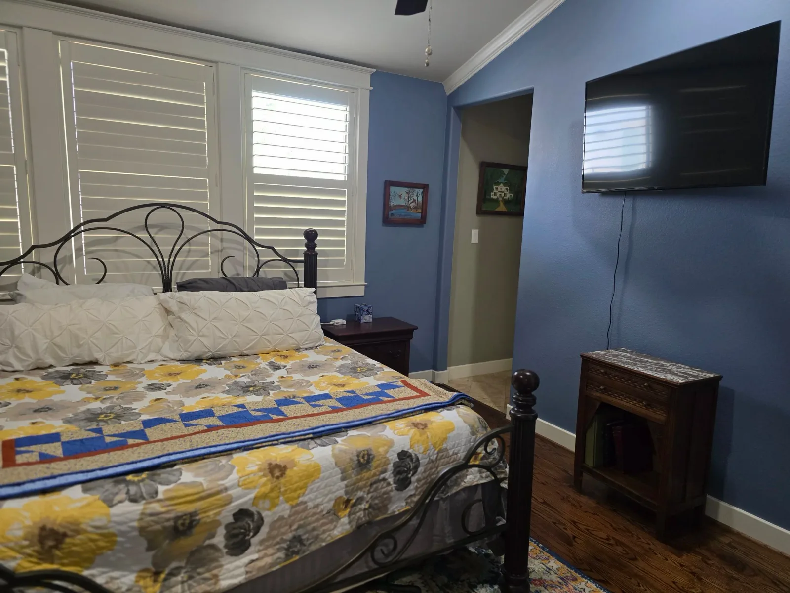 Interior bedroom painting in a West Houston home featuring smooth blue walls, white trim, and hardwood floors