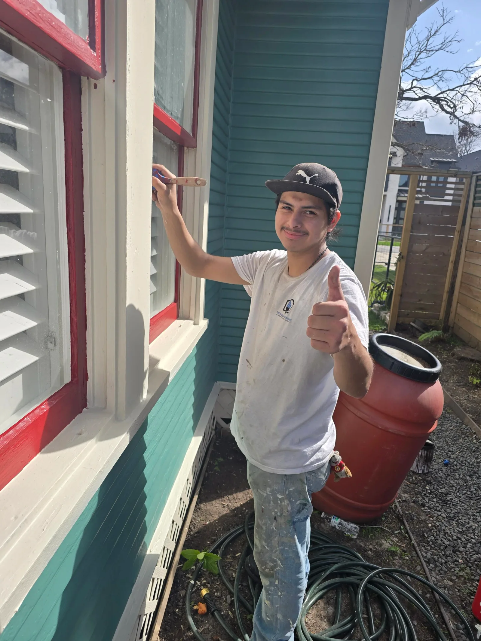 Professional painter performing exterior prep and trim painting on home in West Houston, TX for The Proud Paintbrush.