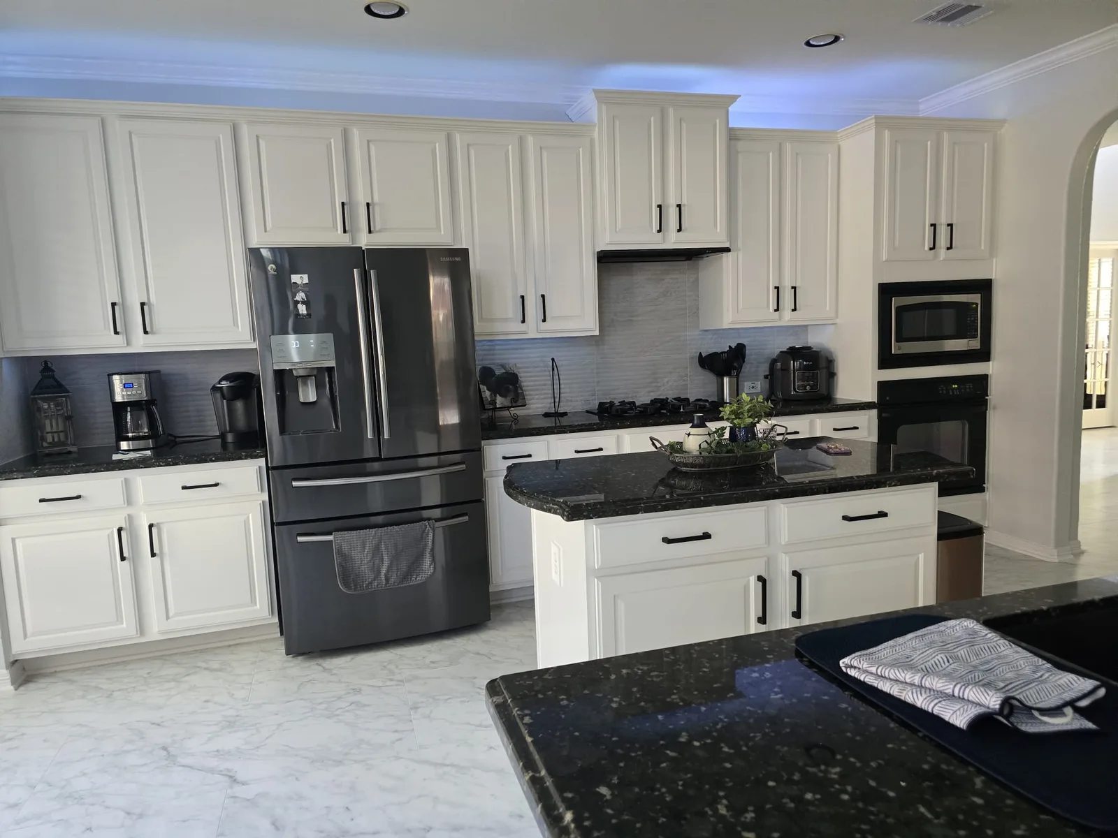 Refinished white kitchen cabinets after cabinet painting in a Cinco Ranch home in Katy, TX