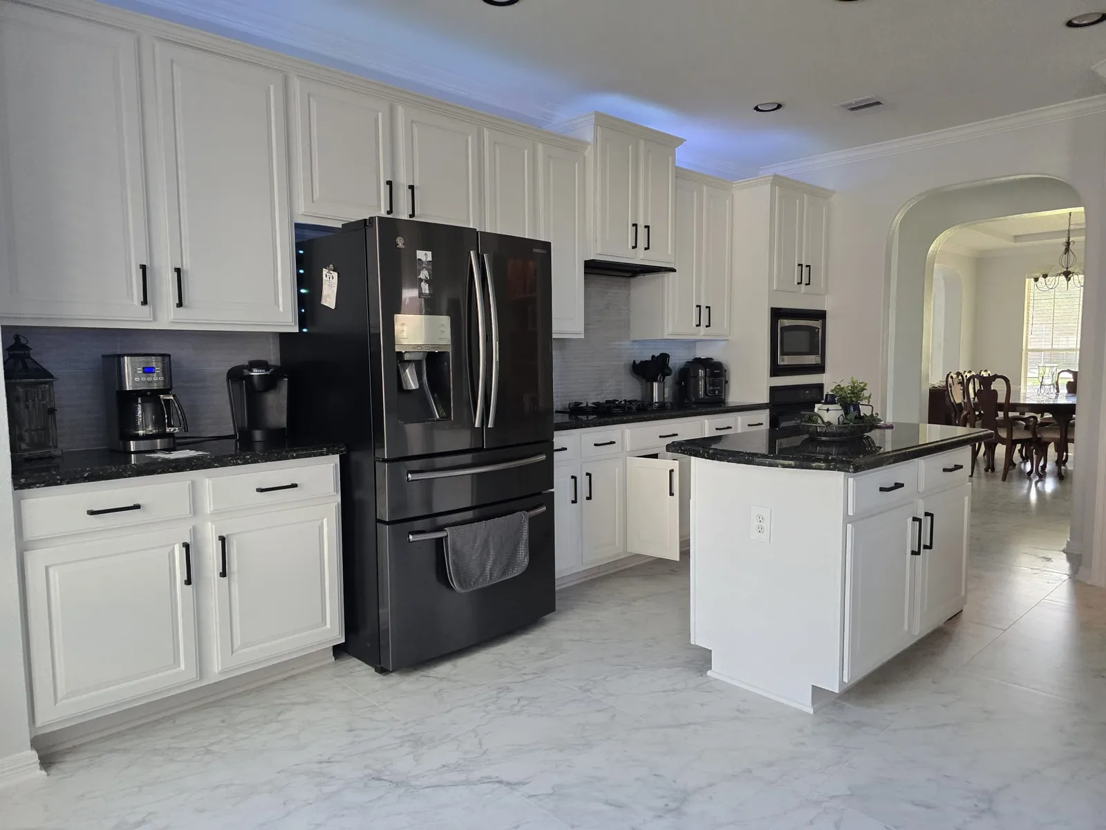 Kitchen island cabinets refinished in Sherwin-Williams Snowbound with Extra White trim in a Cinco Ranch home in Katy, TX