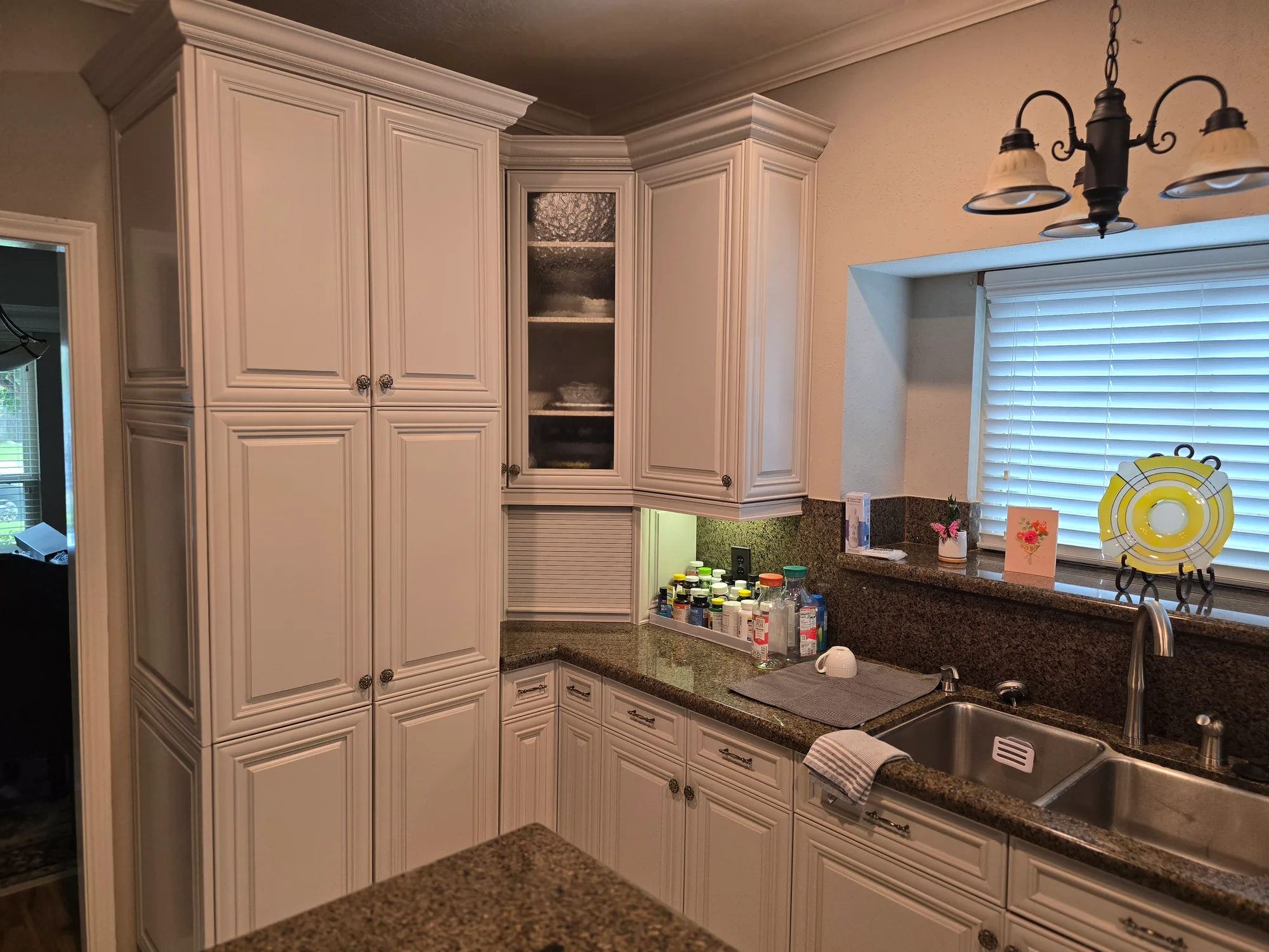 Refinished pantry cabinets in Revere Pewter beside granite countertops in a Katy, TX kitchen